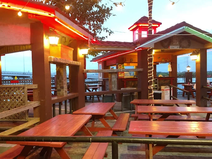 Covered waterfront patio with red picnic tables