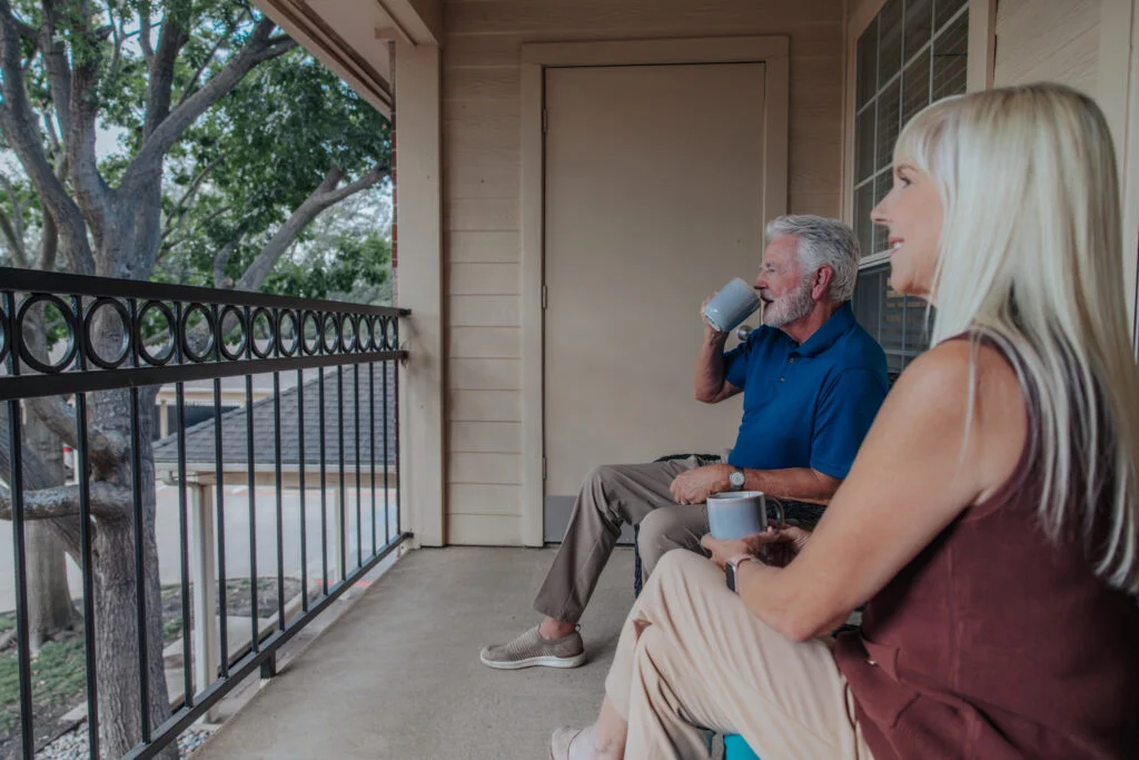 Senior couple relaxing with drinks on an apartment balcony