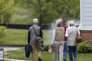 Group of seniors walking together along a path beside a pond