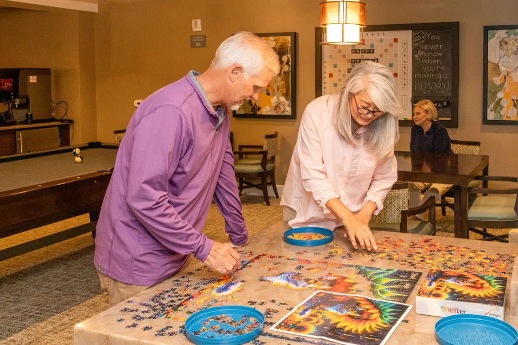 Seniors working on a jigsaw puzzle together at a table