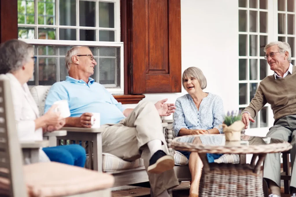 Group of seniors sitting outside on a patio talking