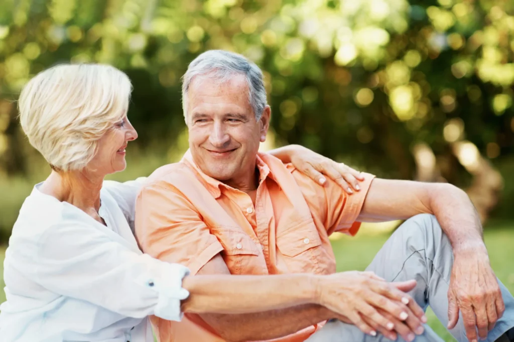 Senior man and woman sitting outside enjoying the sunshing