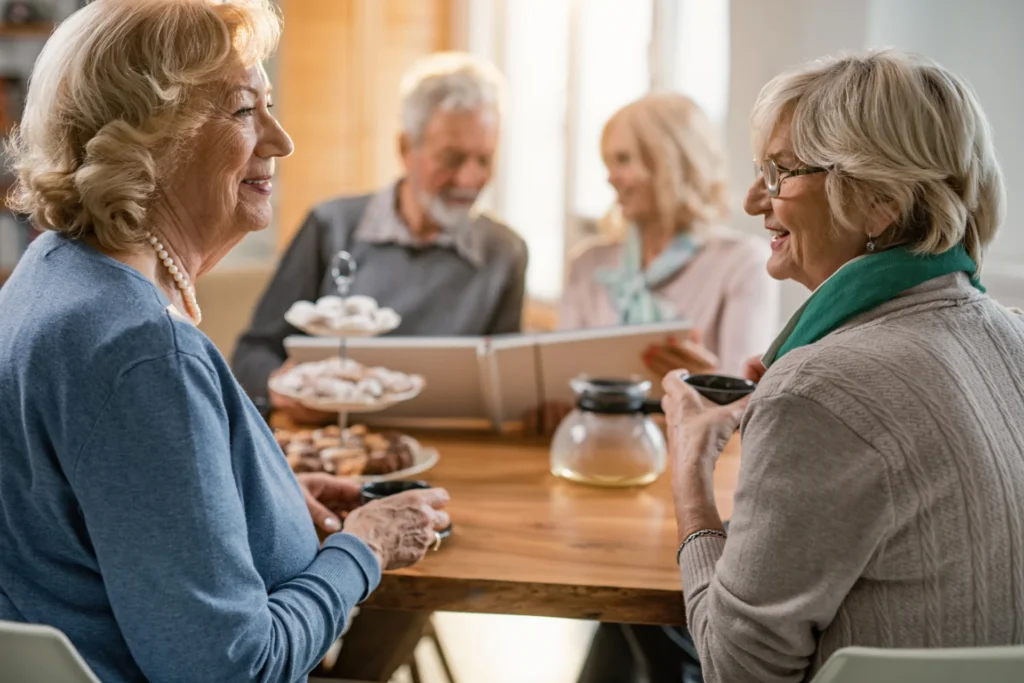 Group of seniors sitting at a table drinking coffee and talking together