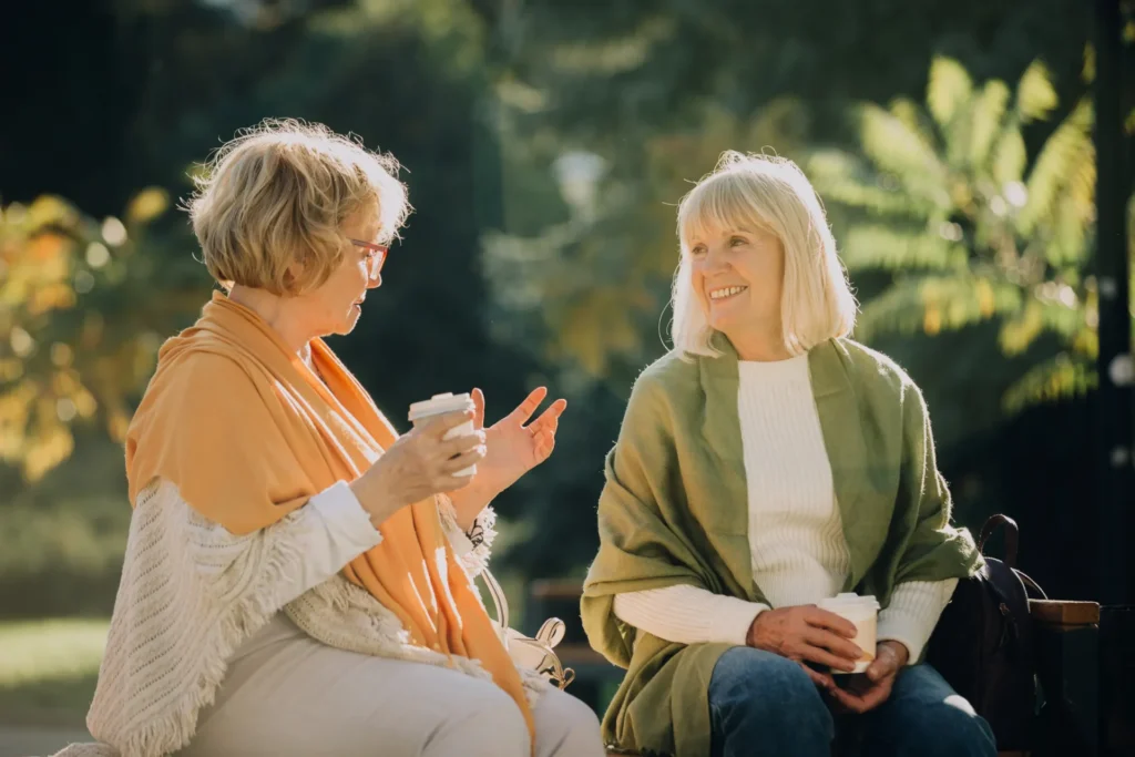 Senior women talking and drinking coffee in the sunshine